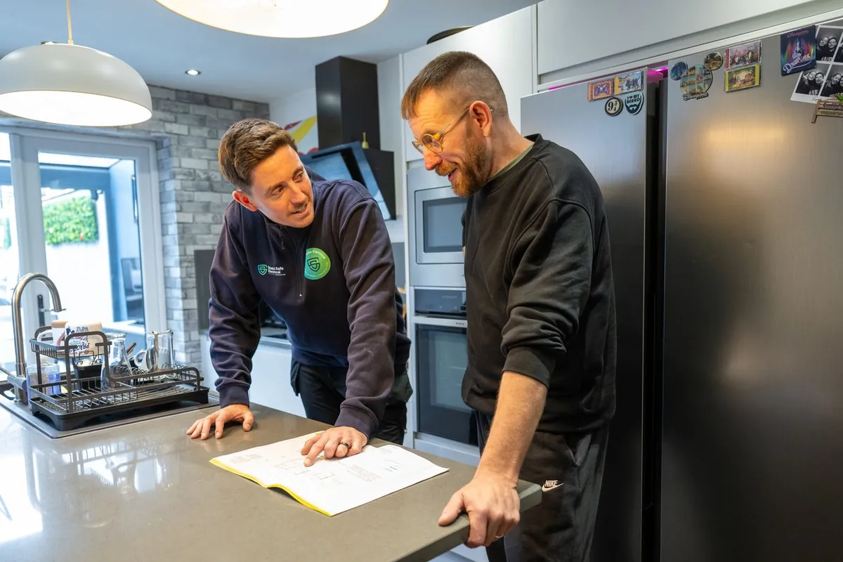 A Shield Safe Electrical electrician talking a customer through the work in their kitchen